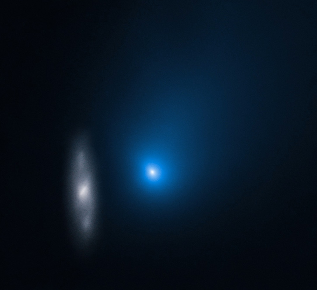 Two interstellar objects passing through the darkness with a blue light in between them.
