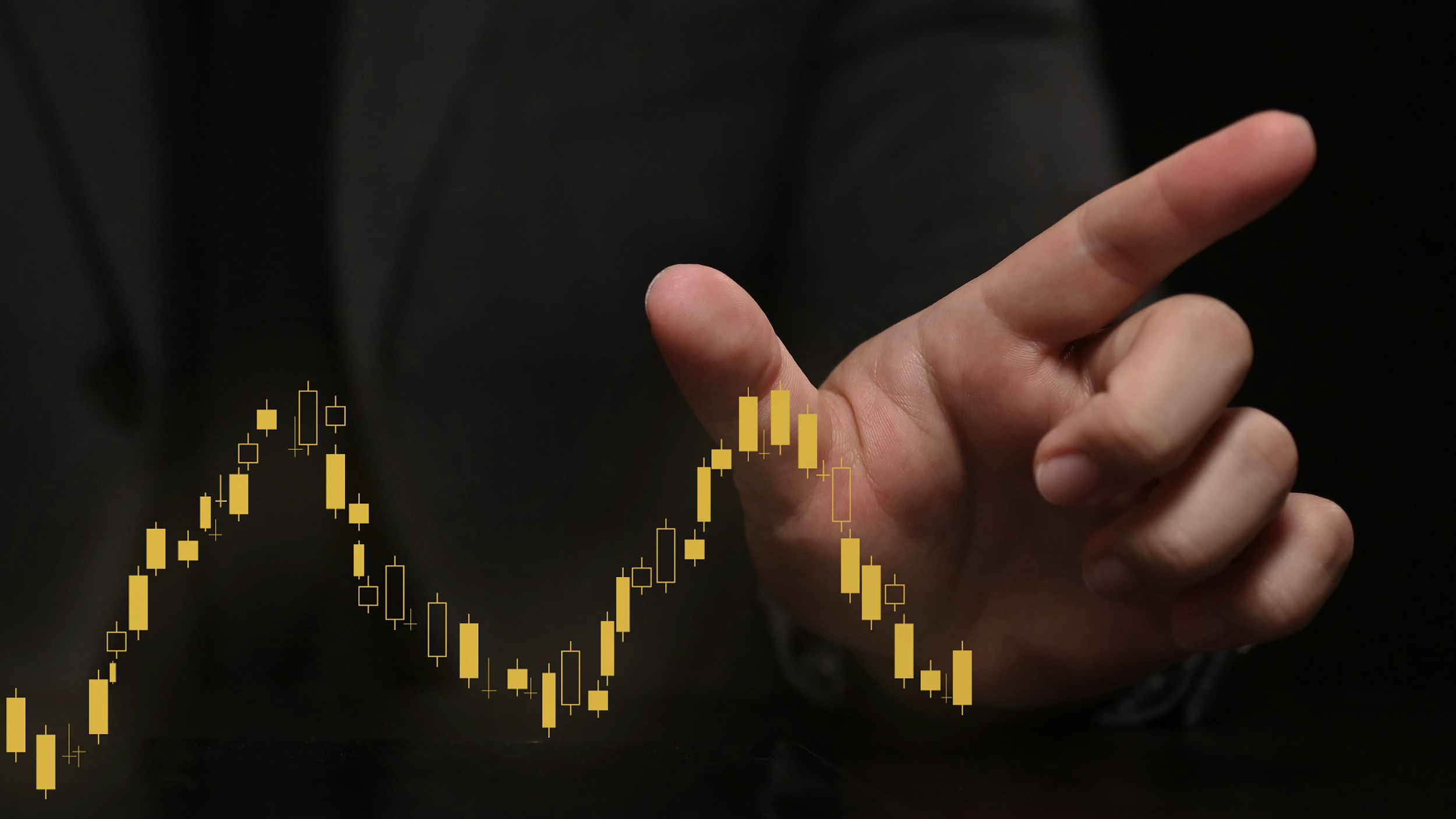 A businessman's hand is pointing at a stock chart, showing intentional growth.