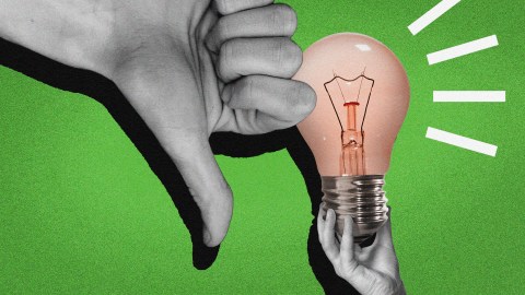 A hand holding a light bulb with a thumbs down, symbolizing a rejection of new ideas.