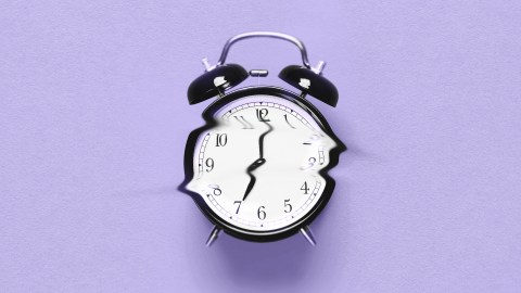 A broken alarm clock on a purple background, reminiscent of a Tali Sharot study.