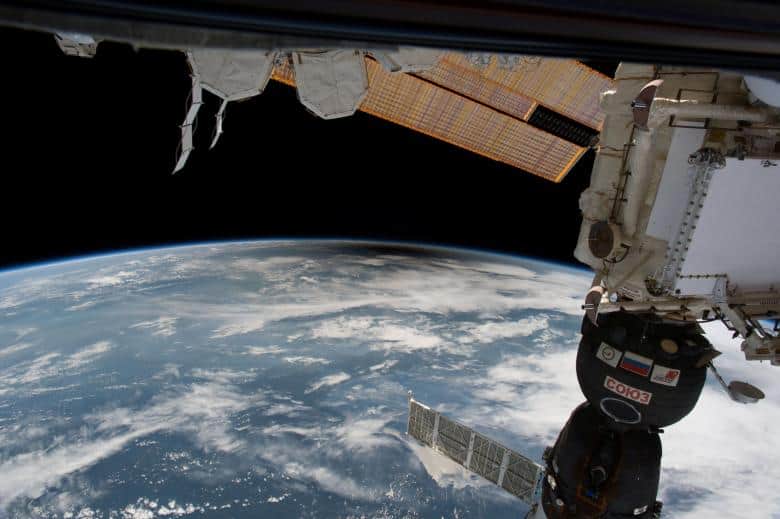The curvature of the earth viewed from space with parts of a space station in the foreground during a total eclipse.