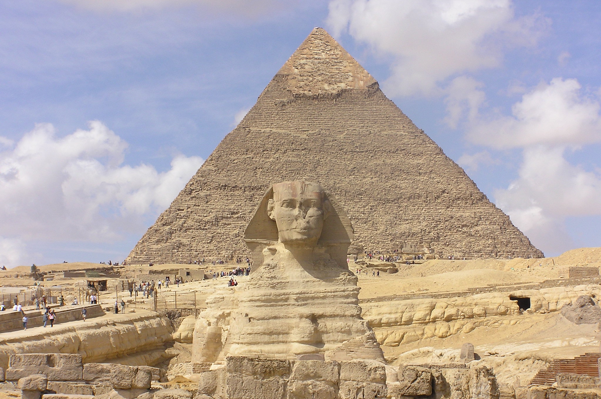 The great sphinx of giza, a magnificent example of human effort to transform earth, with the pyramid of khafre in the background under a clear sky.
