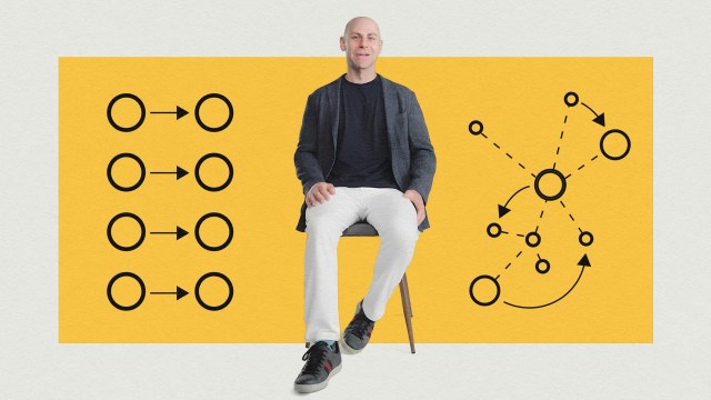 Bald man in casual attire sitting on a stool with a strategic diagram background in yellow.