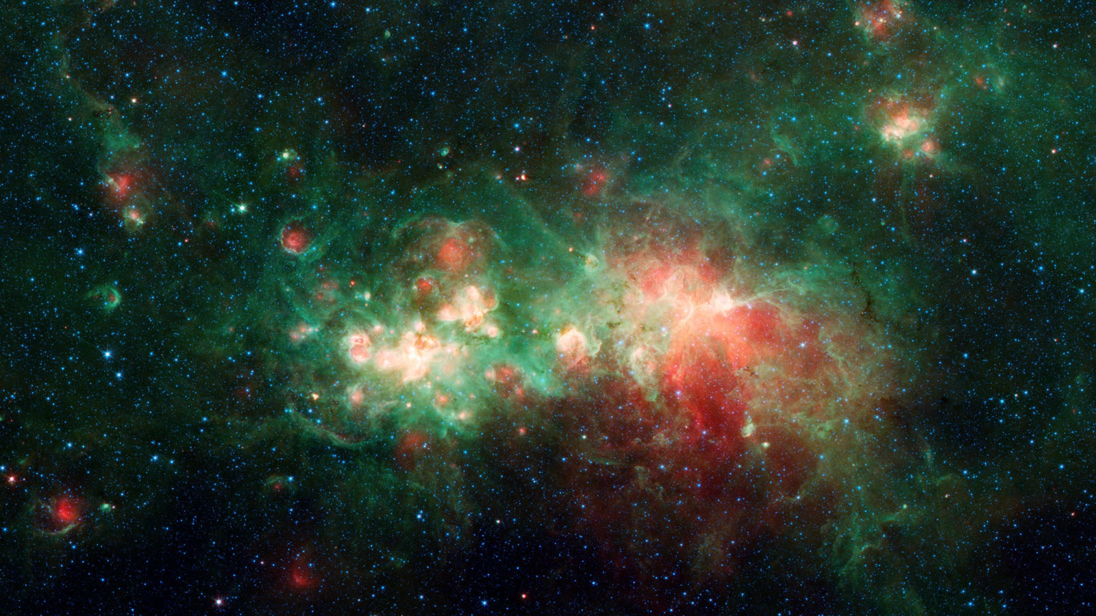 A vibrant space image showing a star-forming region with clusters of bright stars and colorful nebulas in shades of red and green.