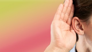 Close-up of a person holding their hand to their ear against a colorful gradient background, implying they are trying to listen more closely.