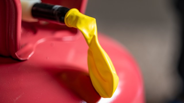 Close-up of a yellow spout on a red gas can, highlighting the detailed texture of the plastic.