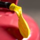 Close-up of a yellow spout on a red gas can, highlighting the detailed texture of the plastic.