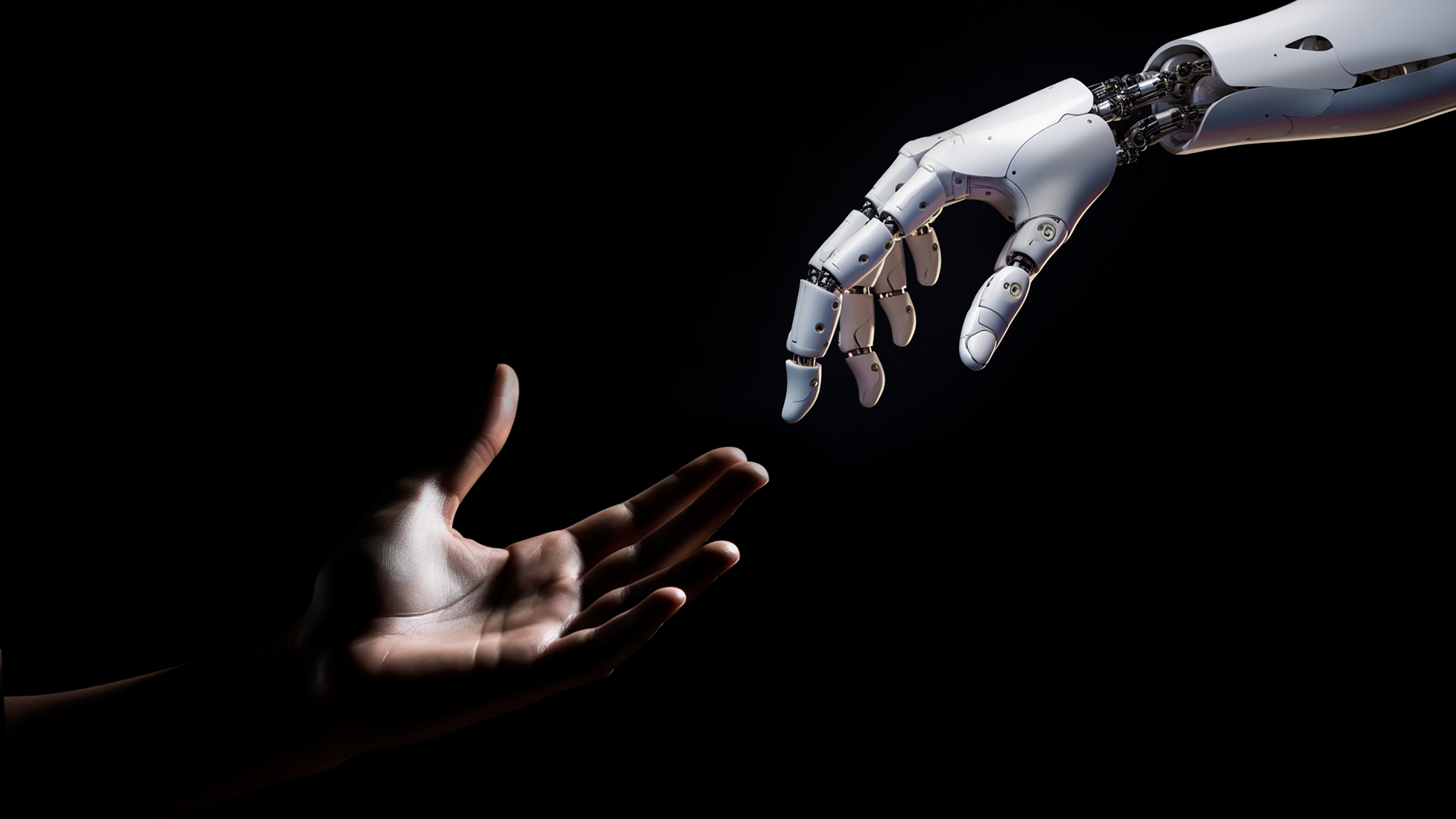 A robotic hand and a human hand reach towards each other against a dark background.