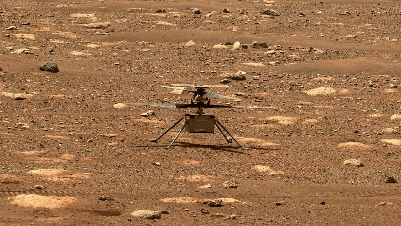 Nasa's ingenuity mars helicopter captured mid-flight on the martian surface, surrounded by rocky terrain.