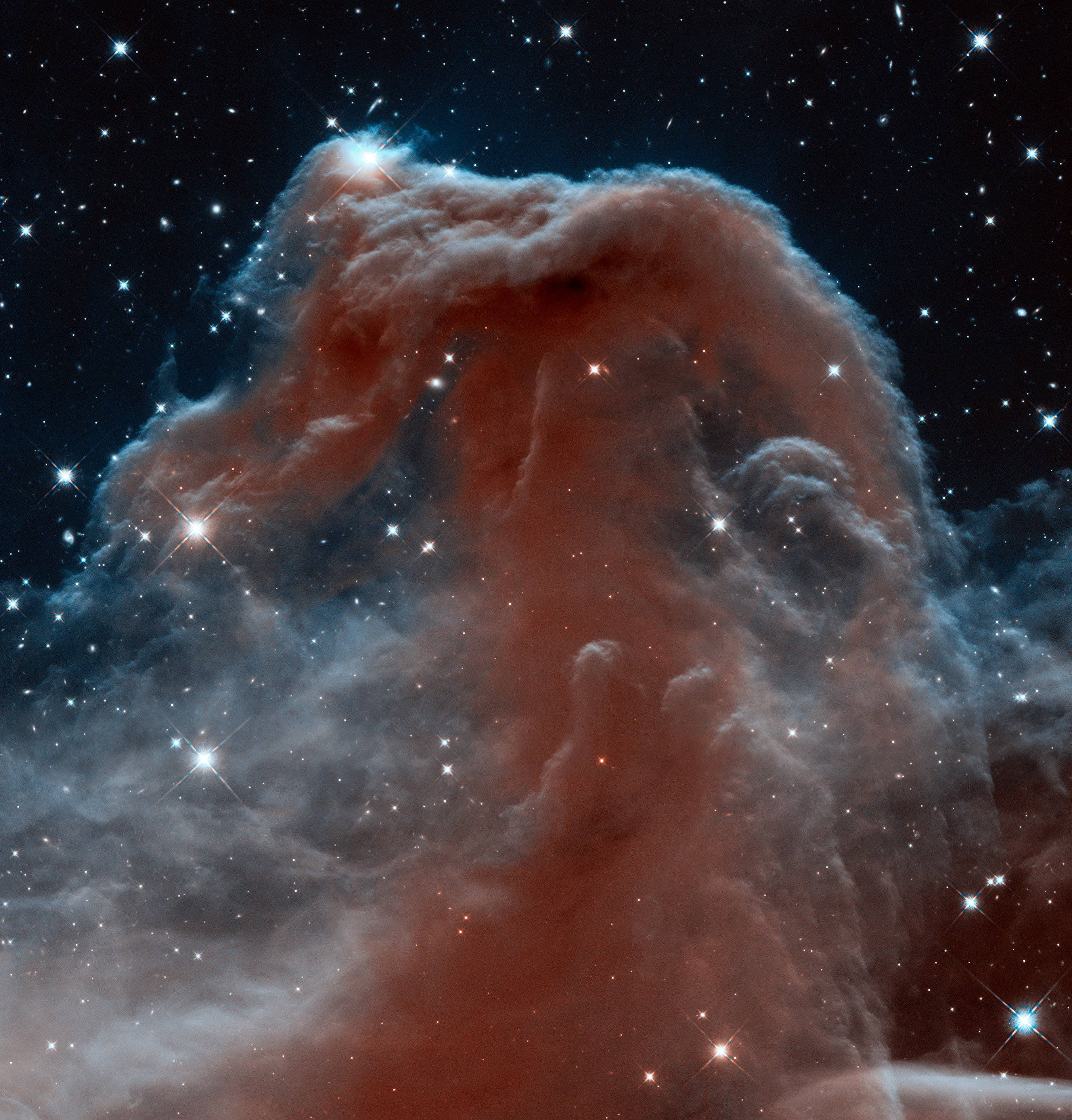 A striking image of the horsehead nebula captured by the JWST, featuring rich red and blue colors with bright stars scattered around it.