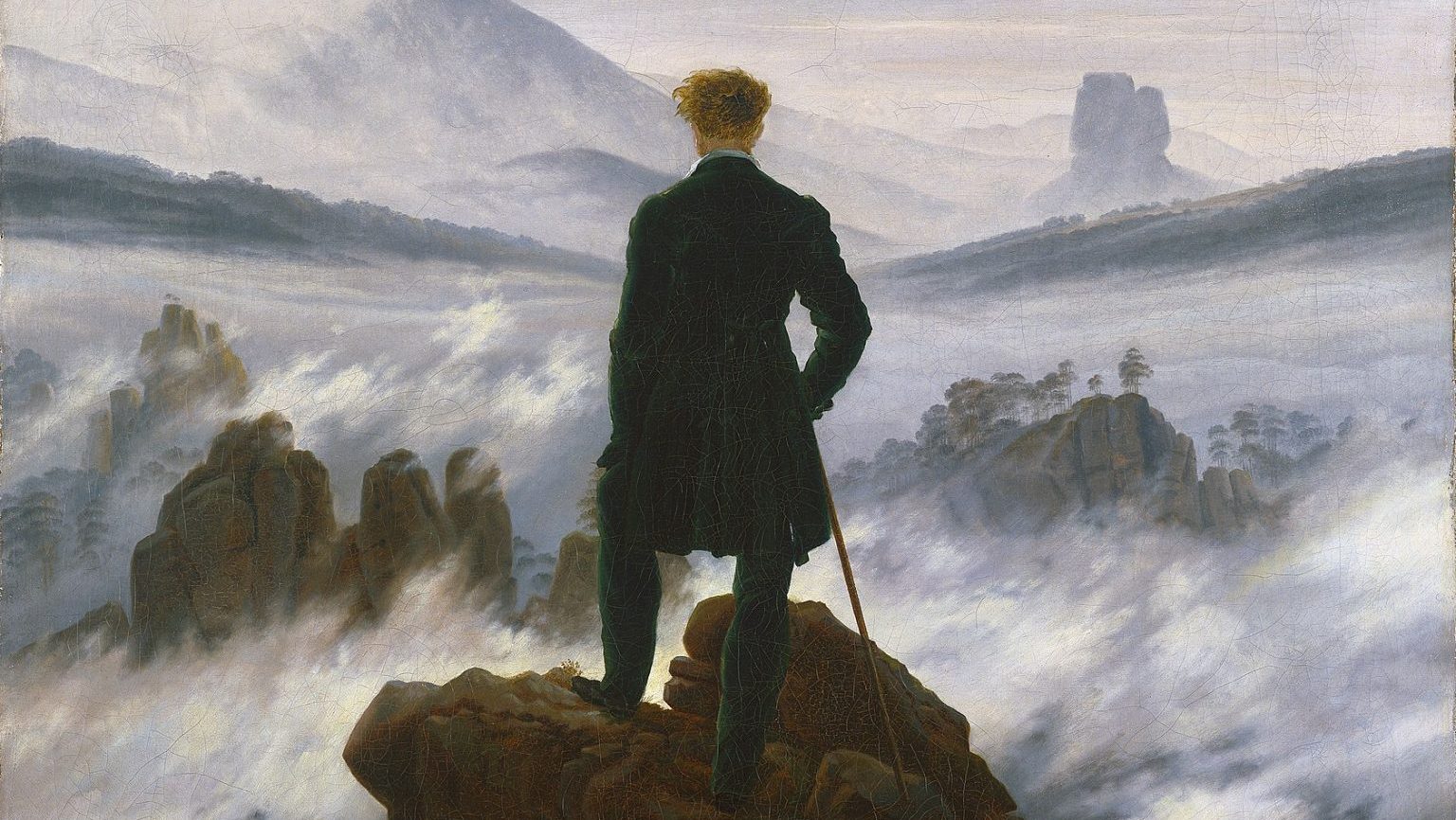 A person stands on a rocky peak, overlooking a foggy and mountainous landscape, holding a walking stick and facing away from the viewer, perhaps contemplating the nihilistic insignificance of human existence in the vastness of nature.