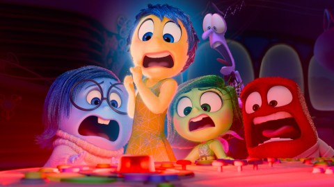 Five animated characters with various expressions of alarm gather around a control panel with a red button.