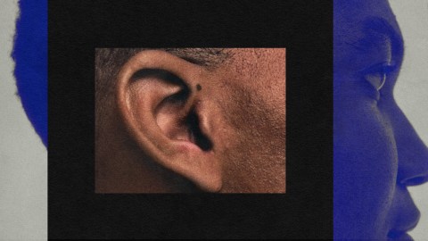 Close-up of a person's ear and partial profile of their face against a black and blue background, embodying the quiet confidence of a leader.