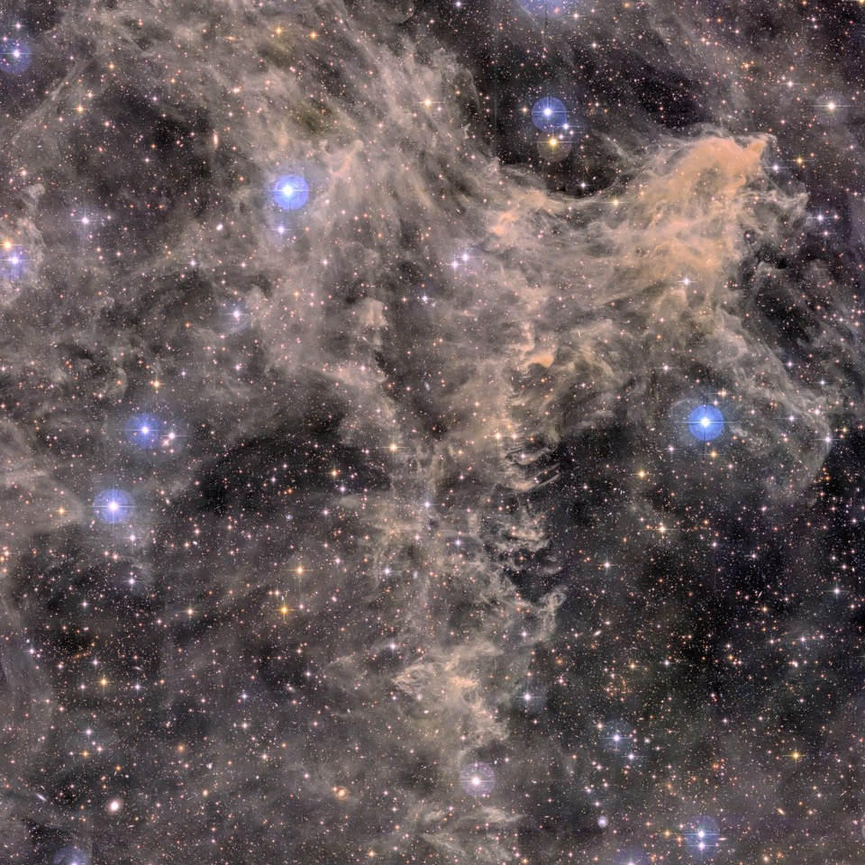 An image of a dark section of space featuring numerous stars and nebulous clouds, with a mix of bright blue stars and wispy, cloudy formations, offering a glimpse into new horizons.