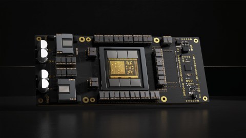 A close-up view of a computer graphics card featuring an array of components, including capacitors, resistors, and a central processing chip, all mounted on a black circuit board.