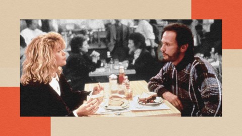 Two people sitting across from each other at a table in a diner, engaged in conversation. The table has plates of food and drinks. The background shows other diners in a black and white setting.