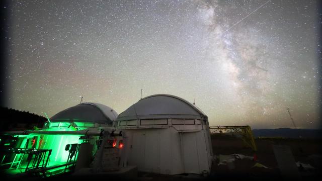 Two observatory domes under a starry night sky, with the Milky Way visible, form a stunning backdrop as an optical interferometer captures the universe's secrets.