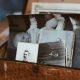 A wooden box filled with assorted old black-and-white photographs and postcards.