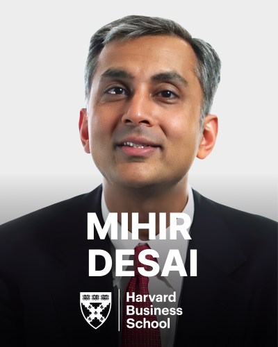 A person wearing a suit and tie is shown with text "Mihir Desai" and "Harvard Business School" along with the school logo in front.