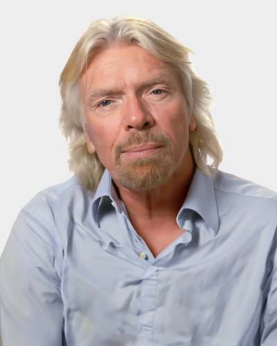 A person with long, light hair and a beard is wearing a light blue button-up shirt, looking forward against a plain background.