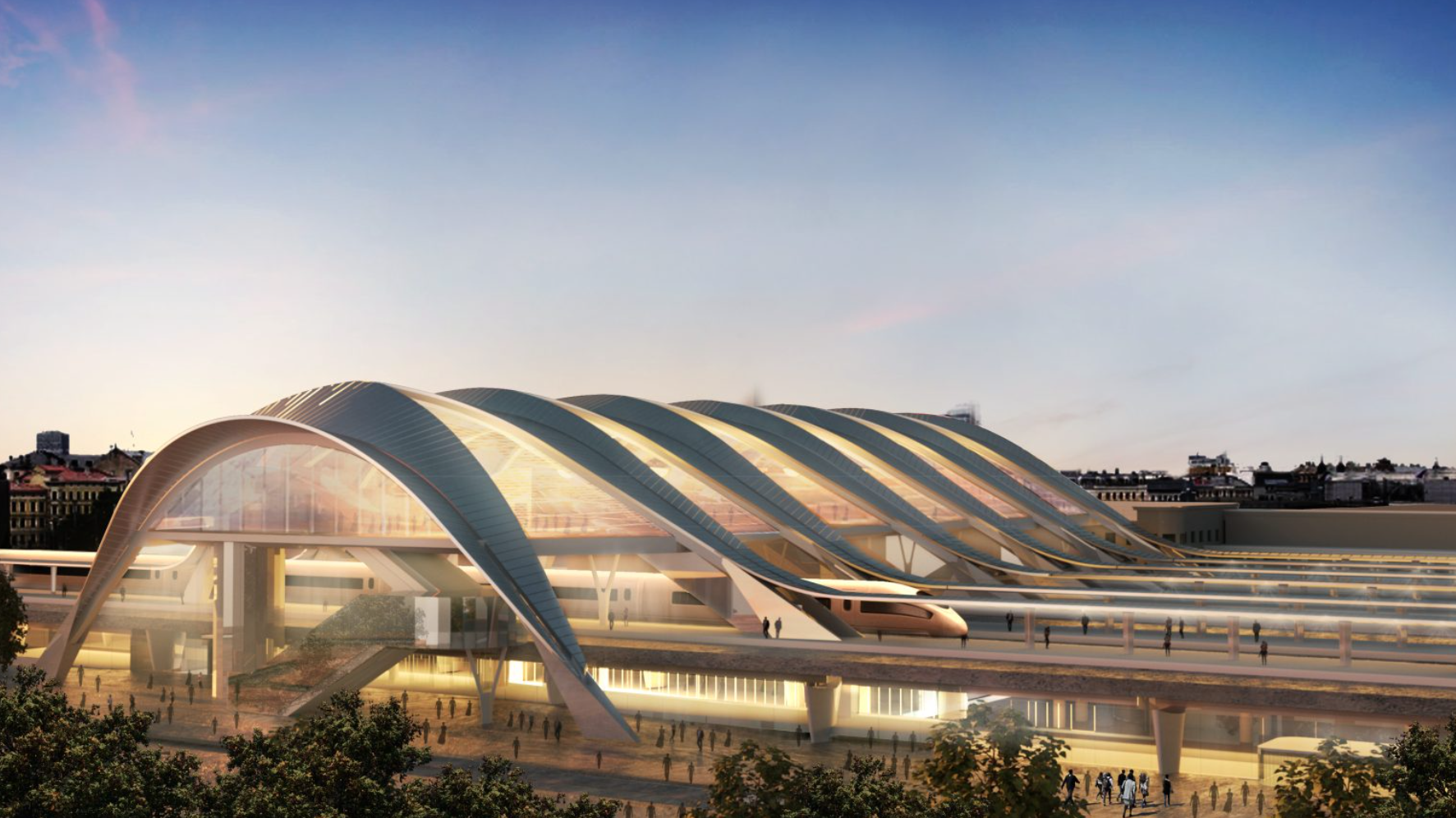 A modern train station with arched glass and steel roof, featuring platforms, a train, and surrounding cityscape during sunset.