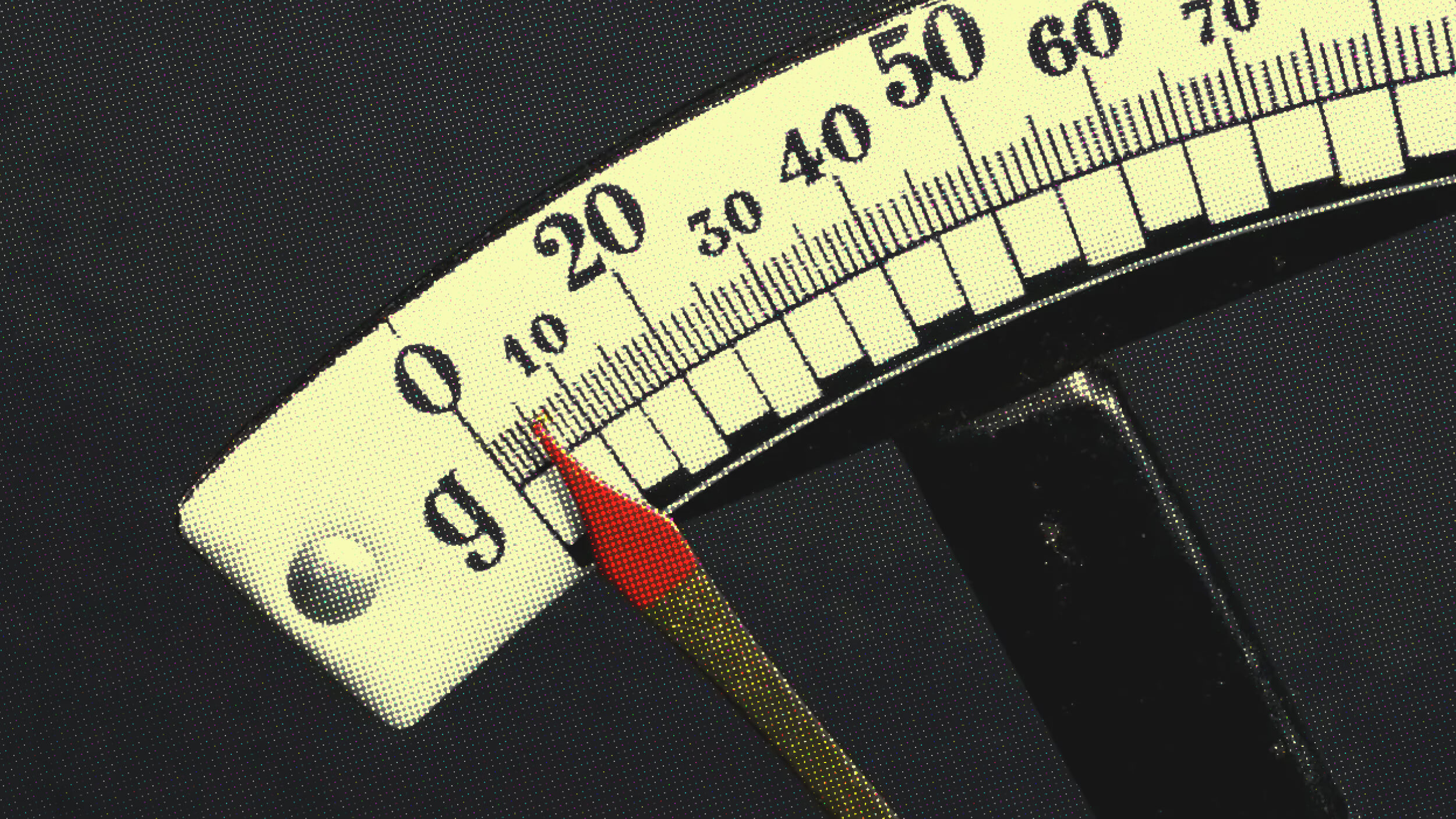 Close-up of an analog weight scale needle pointing to zero grams, with a black background.