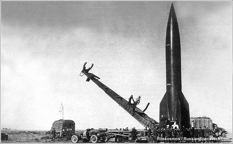 A vintage black and white photo of a rocket on a launch pad, reminiscent of the USA vs. USSR space race era, surrounded by equipment and personnel meticulously preparing for its moon-bound mission.