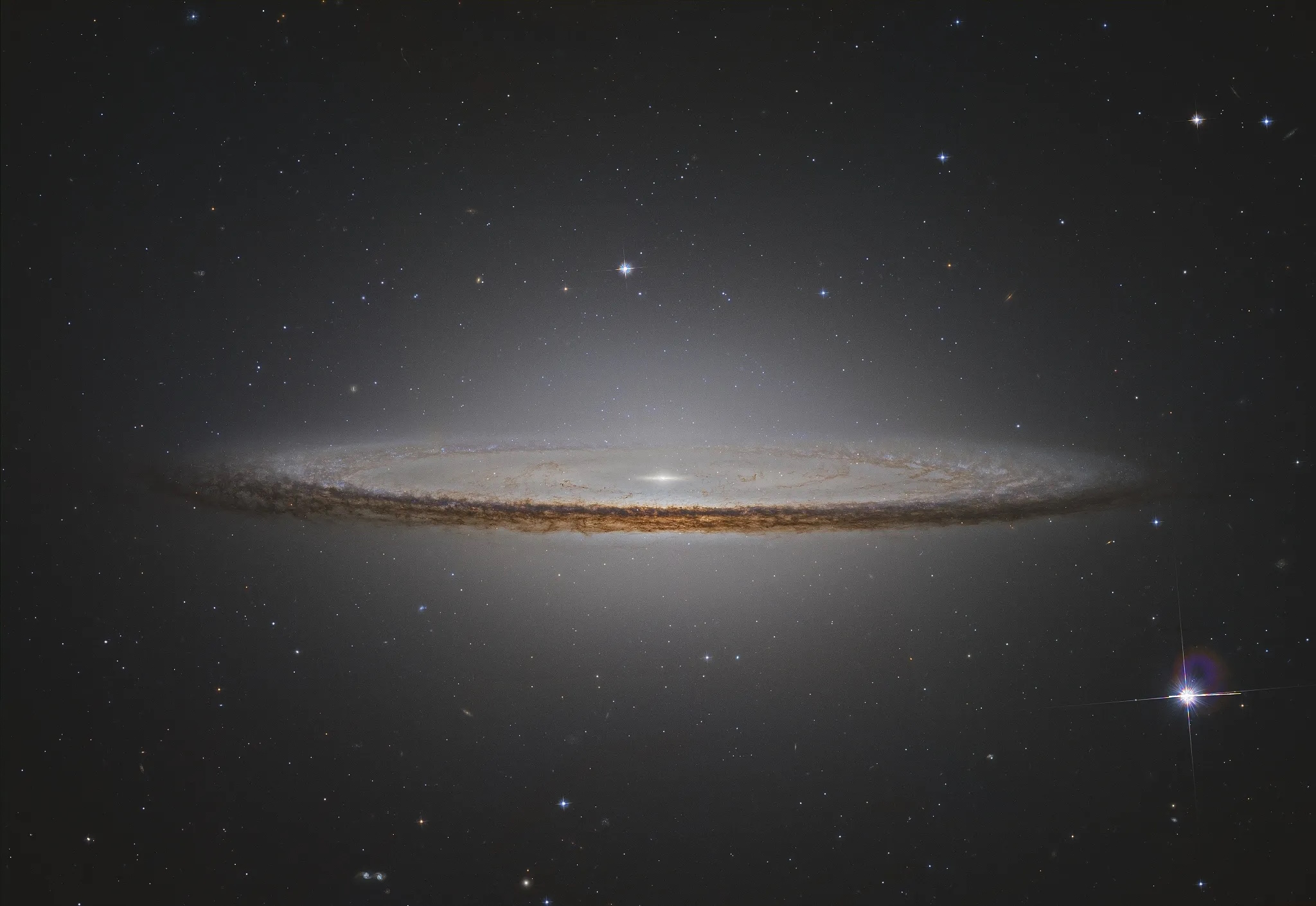 A spiral galaxy, reminiscent of the Sombrero Galaxy, with a bright central bulge and dark dust lanes is beautifully set against a starry expanse in space, evoking images captured by JWST.