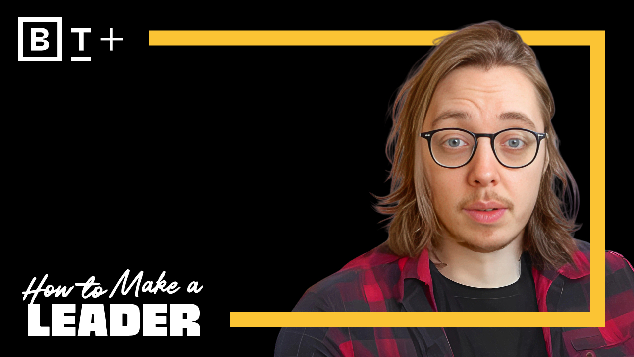 Person with long hair and glasses wearing a red and black checkered shirt.