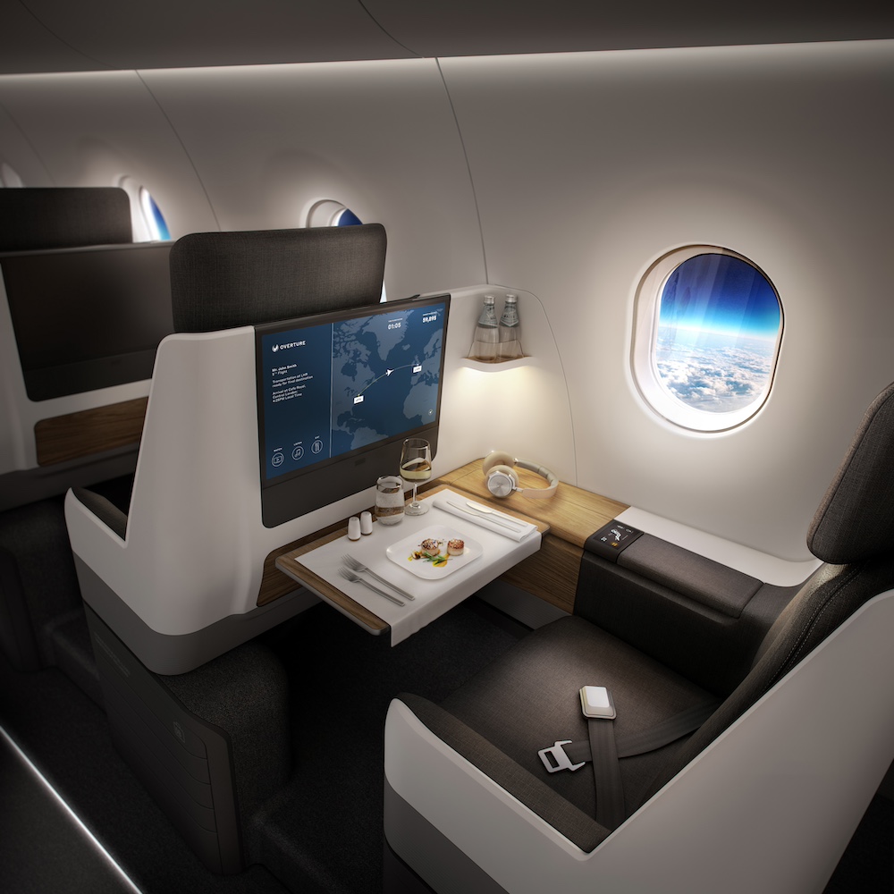 Luxurious airline seat with a large screen, a meal tray, and a window view of clouds and Earth from high altitude.