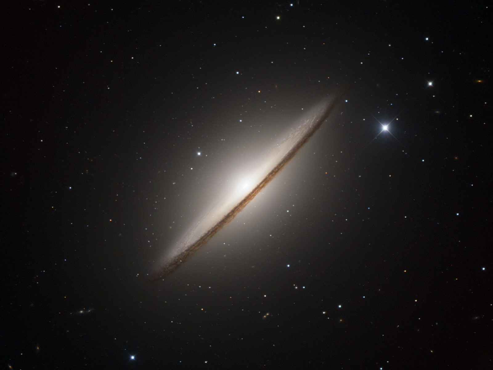 The JWST captures a stunning image of the Sombrero Galaxy, featuring a bright core and a distinct outer ring of dust and stars, all set against a backdrop of numerous distant stars.