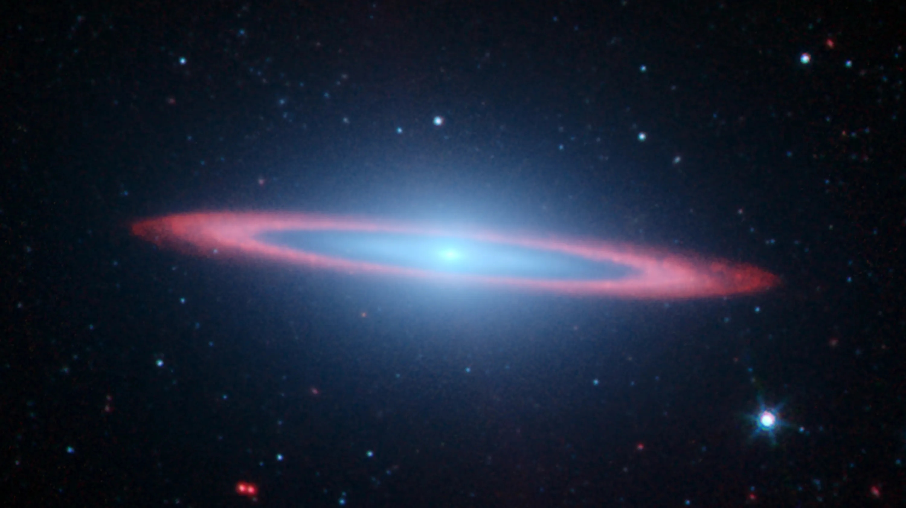 A spiral galaxy reminiscent of the Sombrero Galaxy, featuring a bright blue core and a glowing red ring, is captured in stunning detail by JWST. It's surrounded by numerous stars set against a dark backdrop.