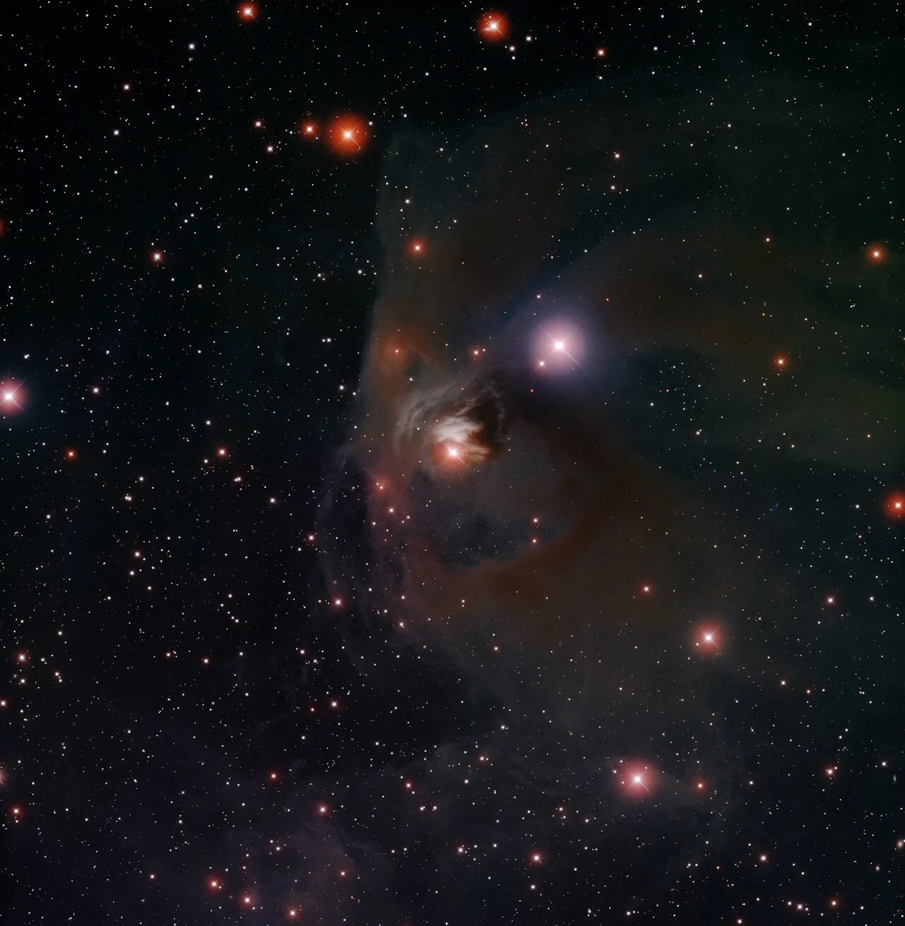 A celestial scene of the NGC 1333 reflection nebula showcases bright stars, dark dust clouds, and a glowing center. Amidst this starry backdrop, dimming T Tauri stars weave tales of youthful stellar evolution.