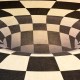 Optical illusion of a black and white checkered floor with a 3D effect creating the appearance of a hole in the ground.