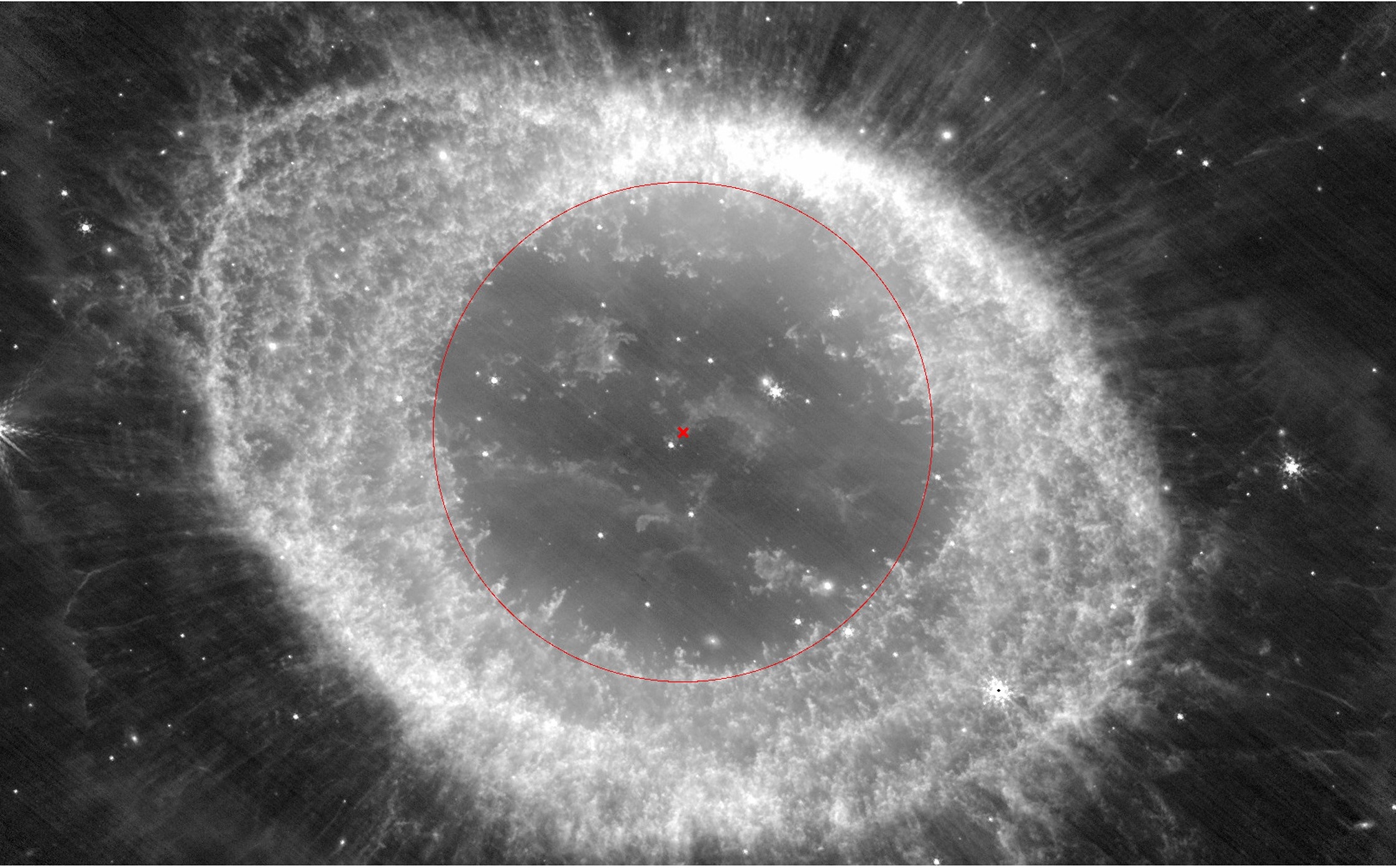 Monochrome image of a nebula with a circular structure and central star, surrounded by a faint halo of gas and dust. The ring nebula's true shape reveals layers that hint at its cosmic secrets, offering a glimpse into the vast mysteries of the universe.