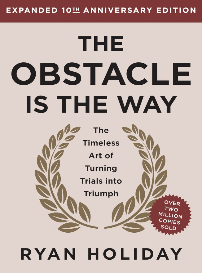 Book cover of the expanded 10th anniversary edition of "The Obstacle Is the Way" by Ryan Holiday. It features a laurel wreath and a note stating "Over two million copies sold," celebrating the art of acquiescence in overcoming life's challenges.