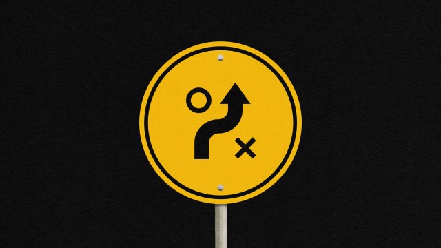 Yellow round sign with black symbols: arrow curving up, circle on left, X on right, on a black background.