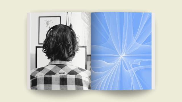 A person with headphones is immersed in framed pictures, next to a book open to a page with abstract blue patterns, reminiscent of human-AI symbiosis in its design.