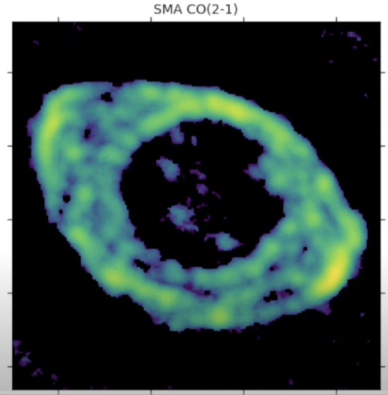 Astronomical image revealing the ring nebula's true shape, featuring a circular, cloudy, ring-like structure with a dark center in green and blue hues, labeled "SMA CO(2-1)".