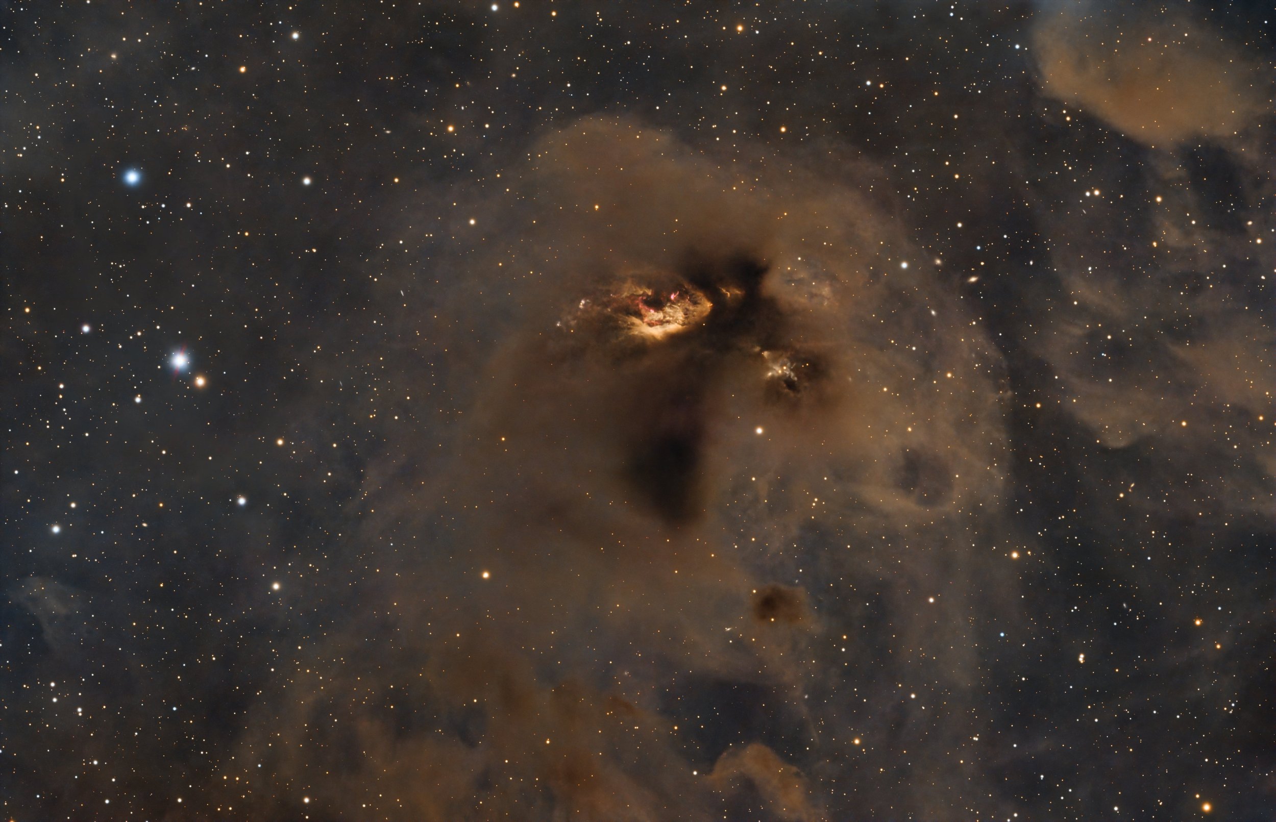 Dark nebula LDN 43, captured by the JWST, reveals a stunning tapestry of star system birth, with stars scattered in the background amidst dense dust clouds and softly illuminated areas.