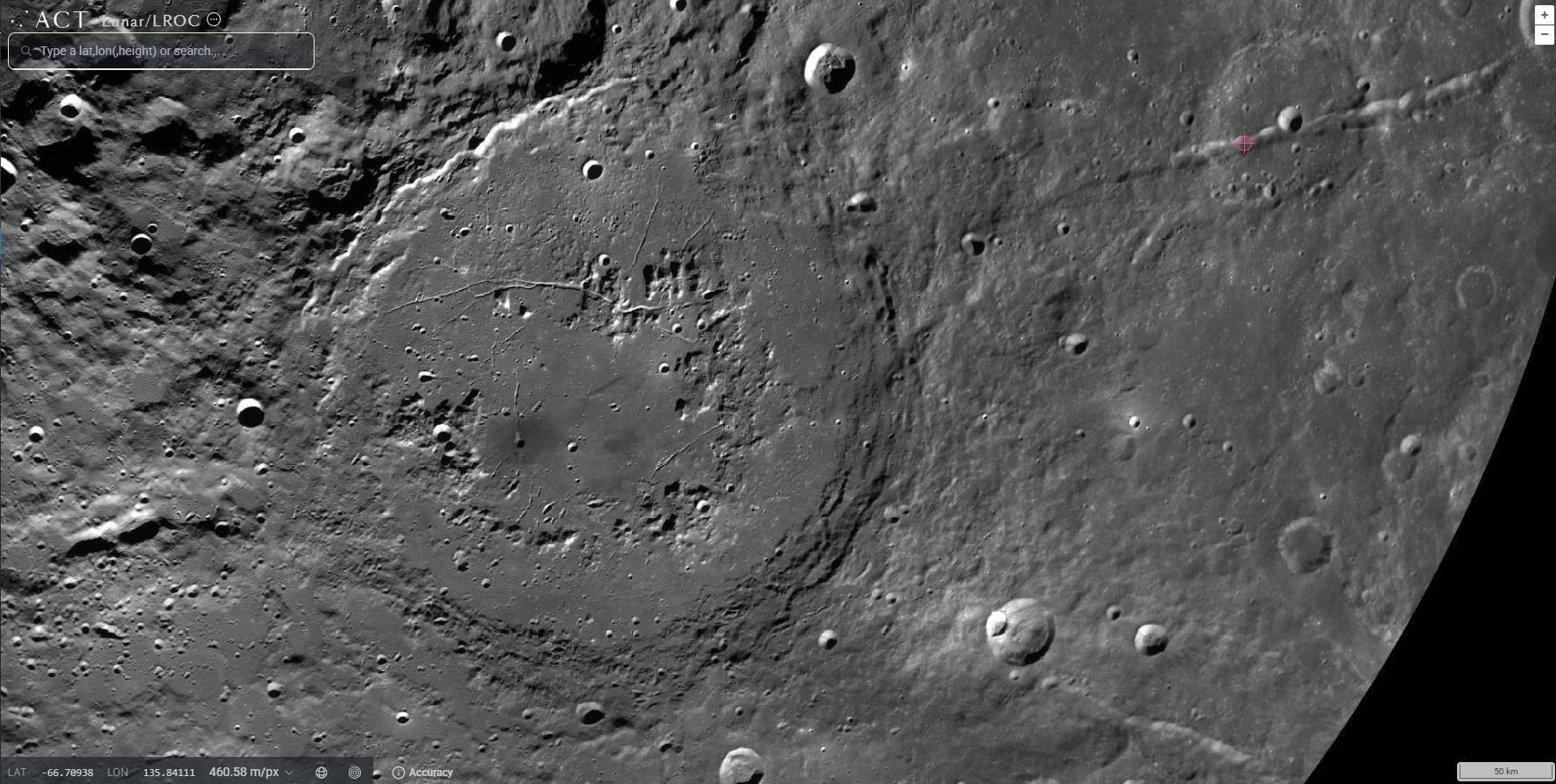 Black and white image captures the grandeur of a large lunar crater, reminiscent of a celestial version of the Grand Canyon, with its rough circular outline surrounded by smaller craters on the moon's surface.