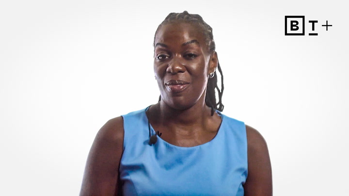 A woman wearing a light blue sleeveless top sits in front of a white background with a BT+ logo in the top right corner.