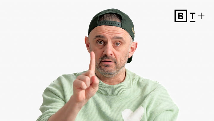 A man in a green sweater and backwards cap holds up one finger, looking forward, with the B+ logo in the top right corner on a white background.
