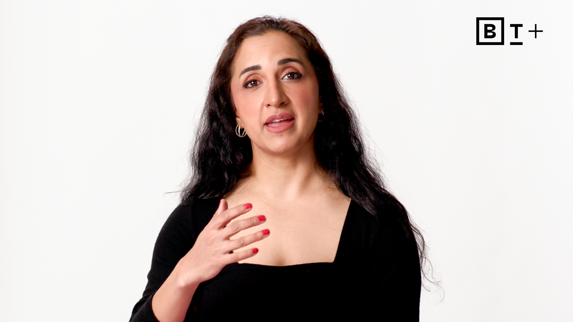 A woman with long dark hair speaks while gesturing with her hand, against a plain white background with the BT+ logo in the corner.
