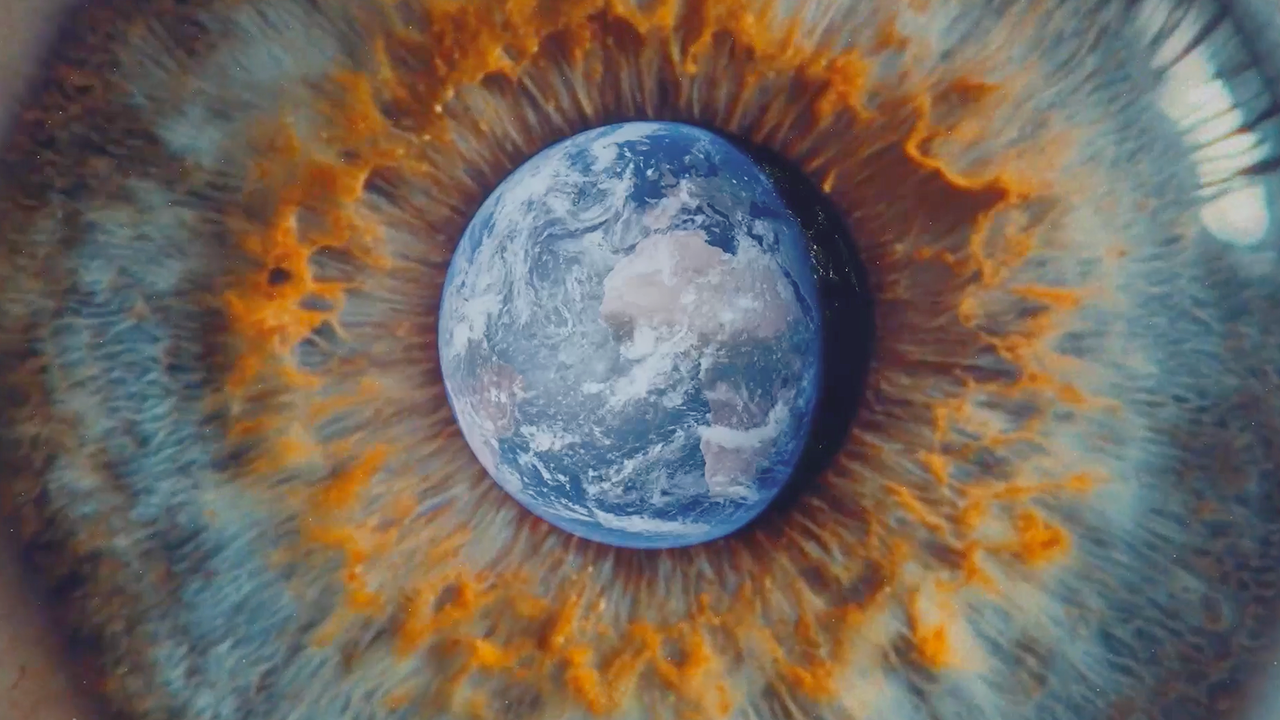 A digitally created image of Earth positioned at the center of a human eye, with the iris displaying vibrant orange and blue patterns.